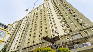 A high-rise building with multiple balconies and a flag. - OYO Life 92718 Apartement Gateway Cicadas (Bandung)