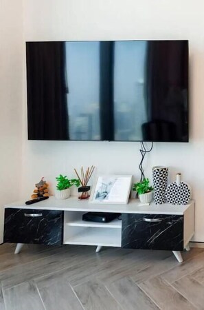Relax in this stylish living room with a flat-screen TV, entertainment unit, and decorative accents.