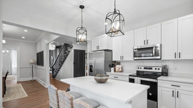 A modern kitchen with white cabinetry, stainless steel appliances, and a central island with seating. - High-End 4bd: hottub, Mini golf, gameroom, firepit (Pittsburgh)