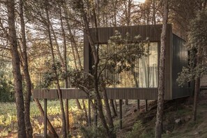 Una cabaña de madera moderna rodeada de árboles.