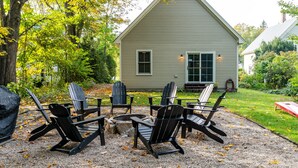 A house with a gravel patio, surrounded by trees and a grassy yard. - Perfect Location in North Conway Village

 (Conway)