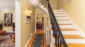 A staircase with a black railing leading to a dining area with a table and chairs. - Perfect Location in North Conway Village

 (Conway)