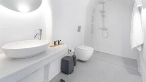 Moderni kylpyhuone, jossa on suuri valkoinen pesuallas, wc ja suihkutila.