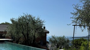A clear swimming pool with a view of a building and trees.