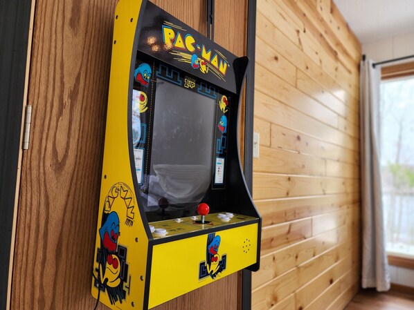 Ein Pac-Man-Spielautomat an einer Holzverkleidung angebracht.