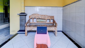 A room with a wooden bench, a laptop, and a pink cloth on the floor. - OYO Life 92841 Kos 88 (Perean Tengah)