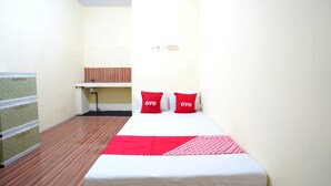 A small, neatly arranged room with a bed, two pillows, a red blanket, a desk, and a chair. - OYO Life 92920 Rumah Kost Azca (Sidoarjo)