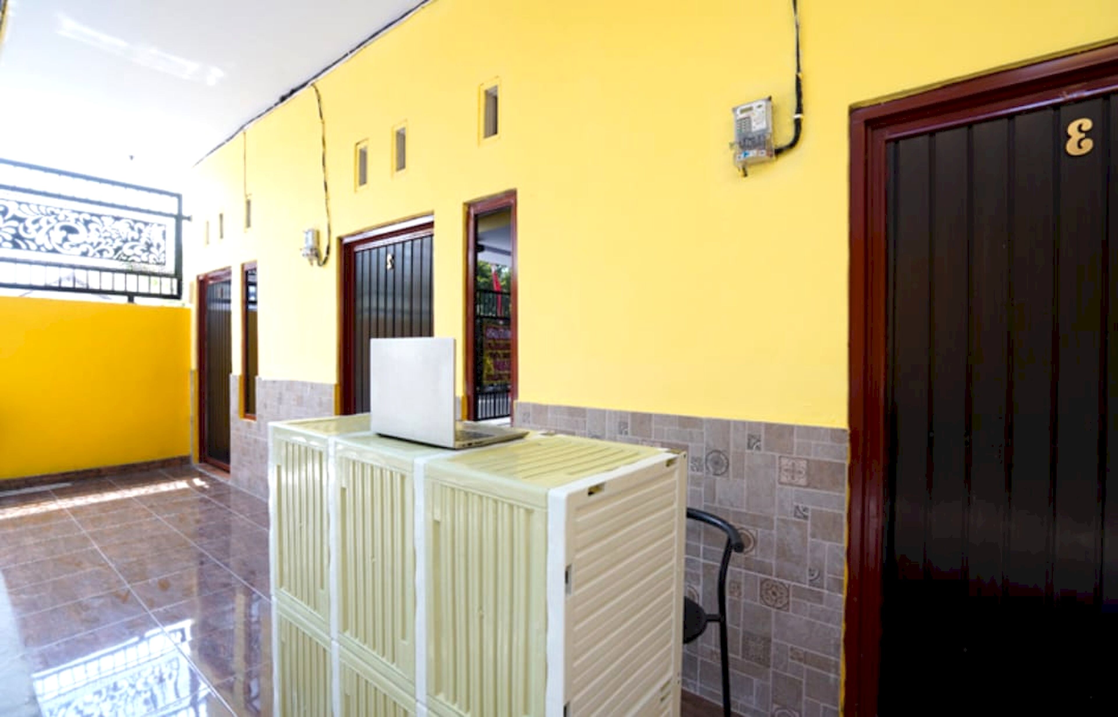 A hallway with yellow walls, a tiled floor, and a door with the number 3.