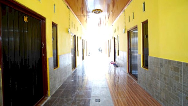 A long hallway with doors on both sides, leading to rooms. - OYO Life 92920 Rumah Kost Azca (Sidoarjo)