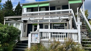 A two-story building with a balcony, a staircase, and a signboard.