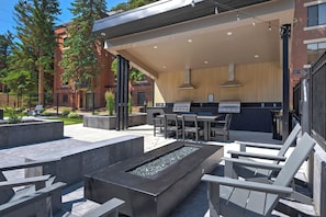 Un patio al aire libre con una parrilla, asientos y una chimenea.