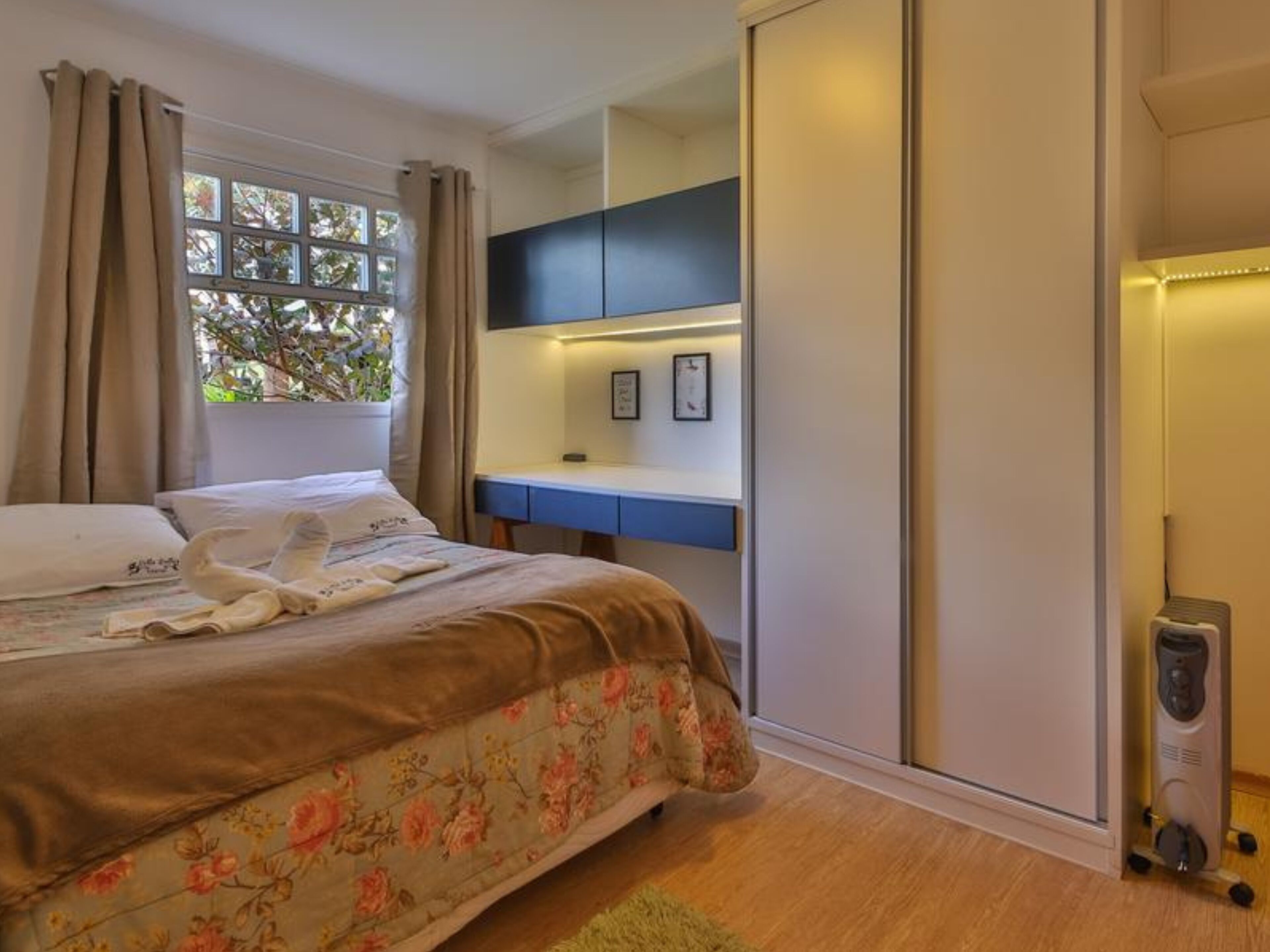 Ein Schlafzimmer mit Bett, Schreibtisch und Kleiderschrank.