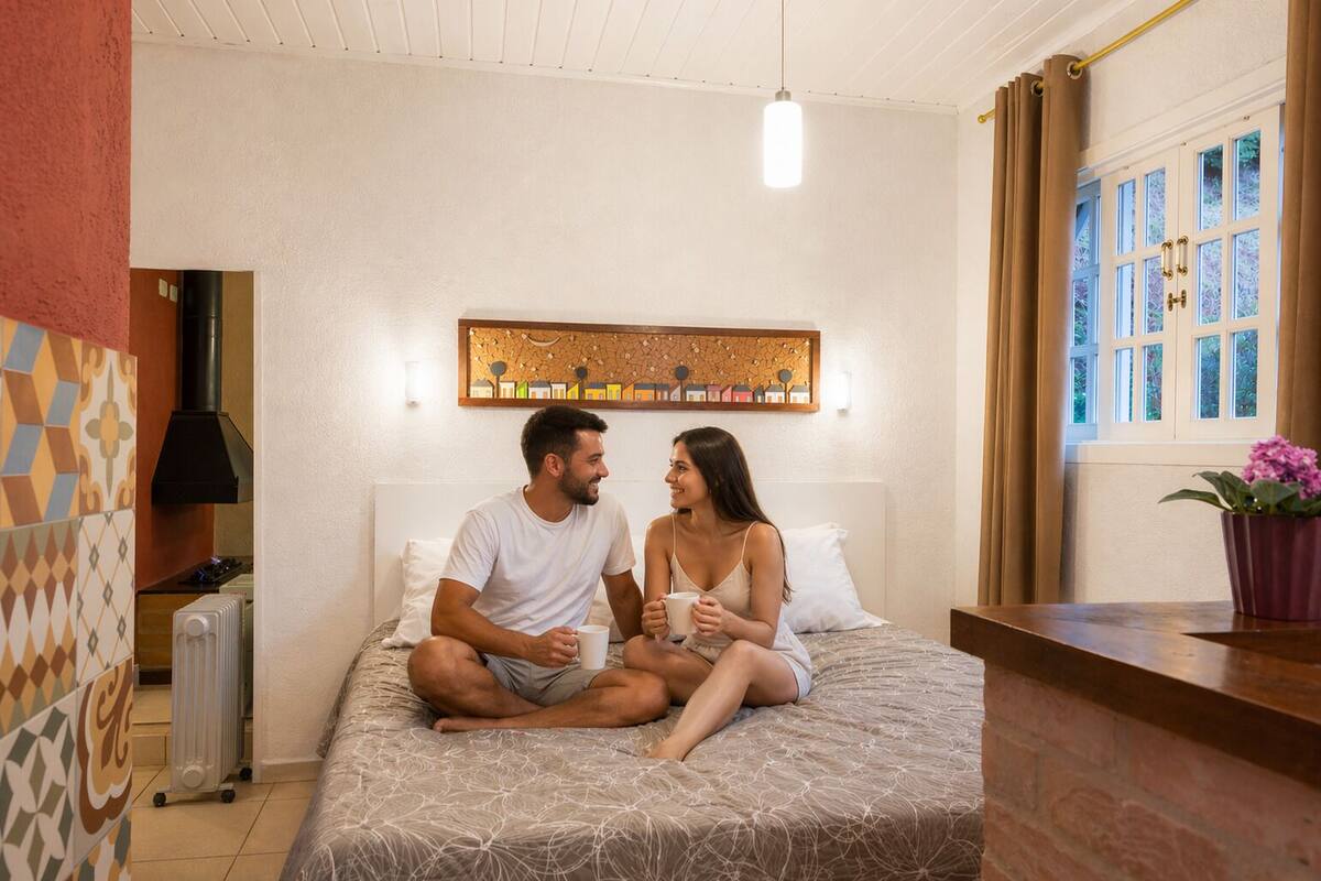 A room with a bed, a radiator, a wall-mounted artwork, and a window with curtains.