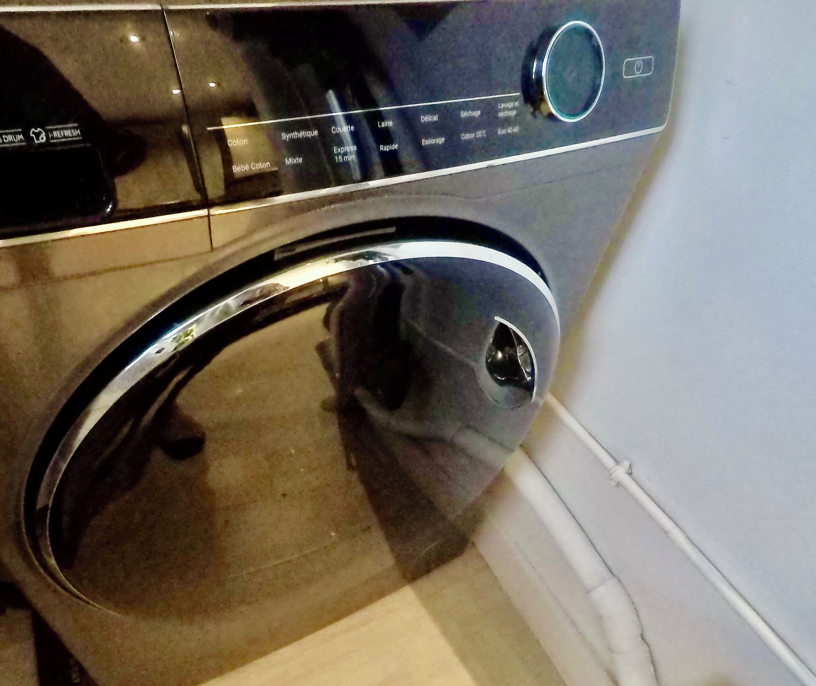 A front view of a washing machine with a control panel displaying various settings.