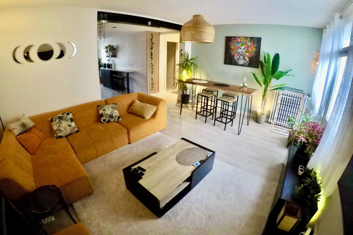 Una sala de estar moderna con un sofá, una mesa de centro y un comedor con una mesa y sillas.