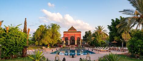 A pool area with lounge chairs and a gazebo.