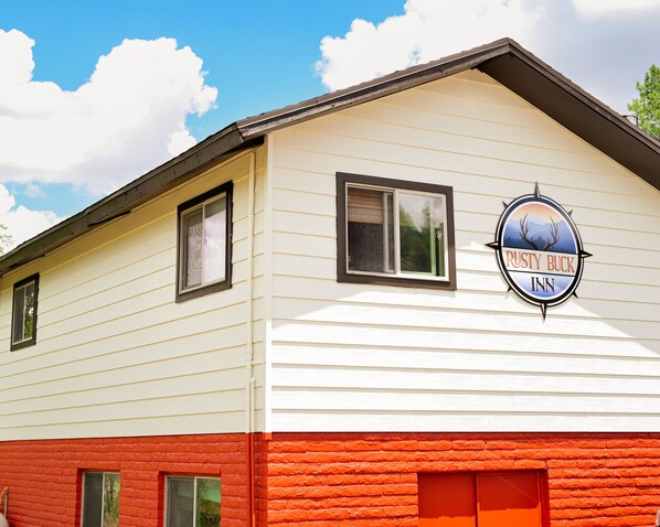 A building with a sign that reads "Rusty Buck Inn" on the side.