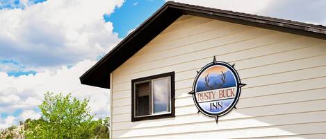 Um edifício rústico com uma placa que diz "Rusty Buck Inn".