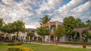 A courtyard with a building featuring arched walkways and a central open space.