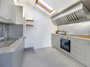 A modern kitchen with a skylight, stainless steel appliances, and a patterned floor. - 2 bedroom accommodation in Llanon Aberystwyth (Llanon Aberystwyth)