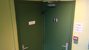 A green door with a sign indicating room numbers 16 to 17 and 18 to 20. - Hôtel Azur (Paris)