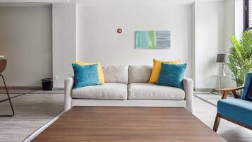 Una sala moderna con sofá, mesa de centro y una planta en maceta.