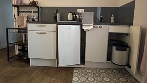 Eine kleine Küche mit Kühlschrank, Spüle und Arbeitsplatte.