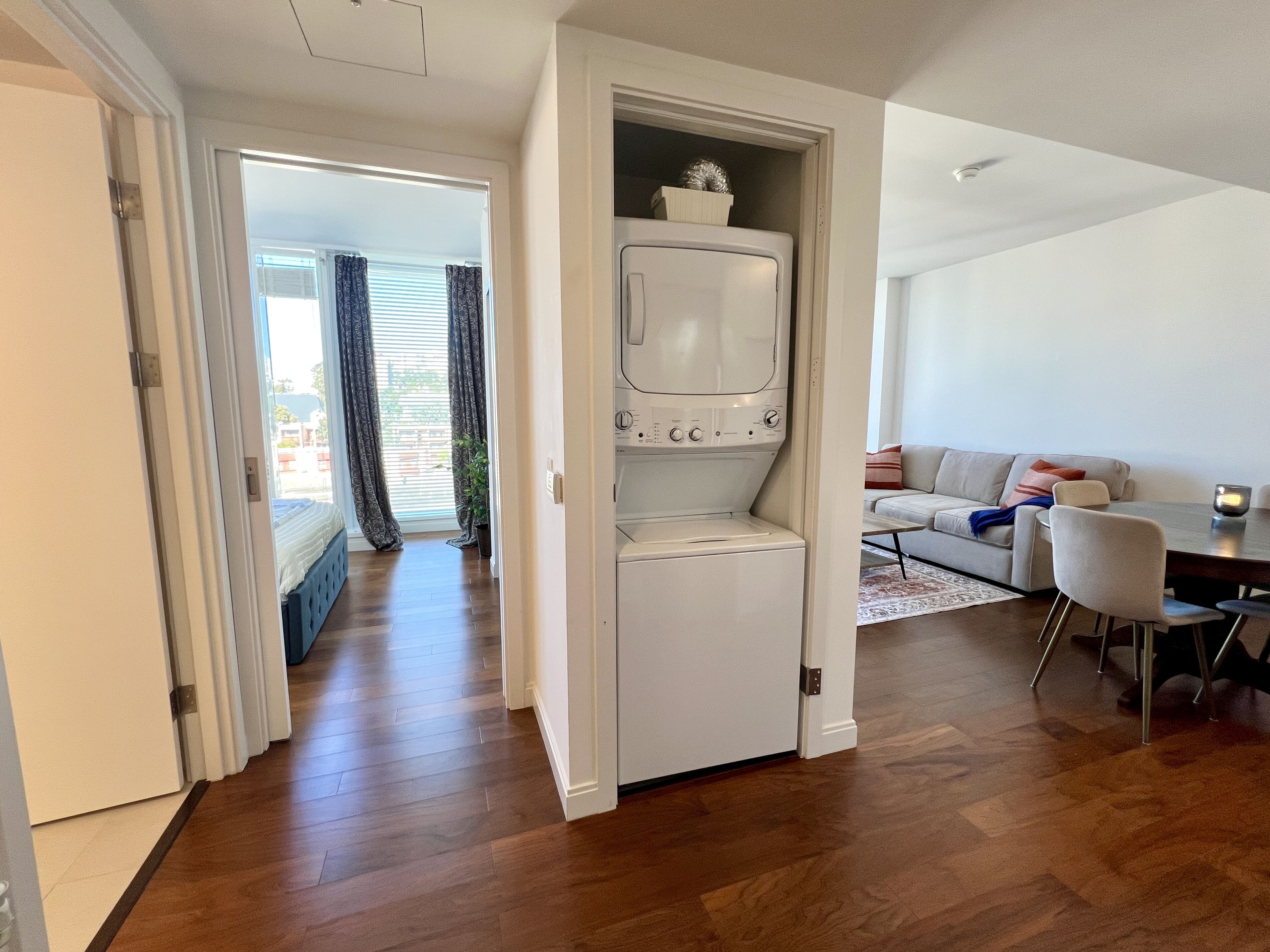 A compact living space with a built-in washer and dryer, a sofa, and a dining area.
