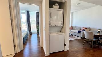 A compact living space with a built-in washer and dryer, a sofa, and a dining area.