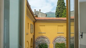 Un bâtiment jaune, doté d’arcades en pierre et d’un toit recouvert de tuiles rouges.