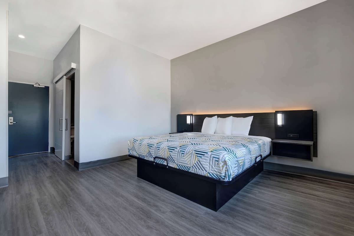 A modern bedroom with a large bed, built-in bedside tables, and a wardrobe.