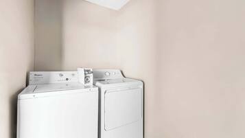 A laundry area with two Whirlpool dryers and a stacked washer and dryer unit.