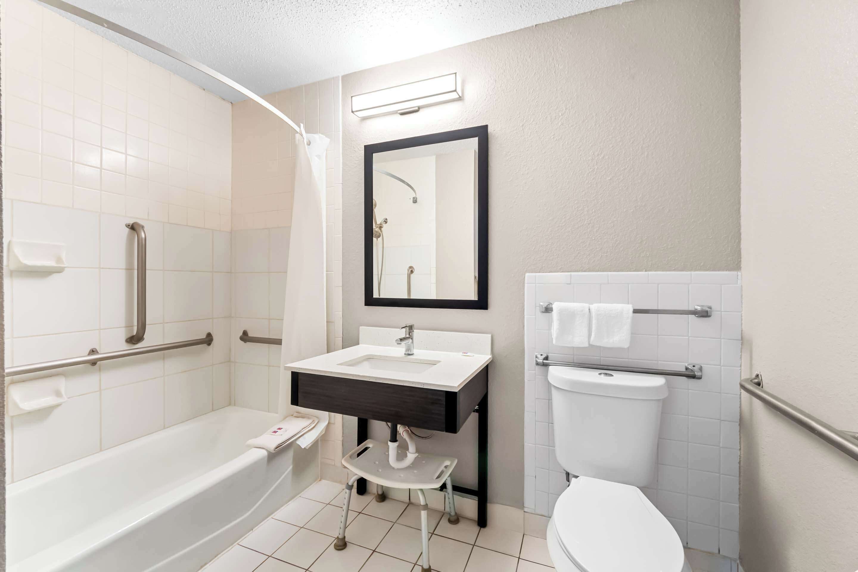A modern bathroom with a bathtub, a sink, a toilet, and a shower.