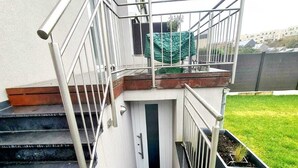 A staircase leading to a door with a small balcony, surrounded by a metal railing. - New Studio in Center (Luxembourg City)
