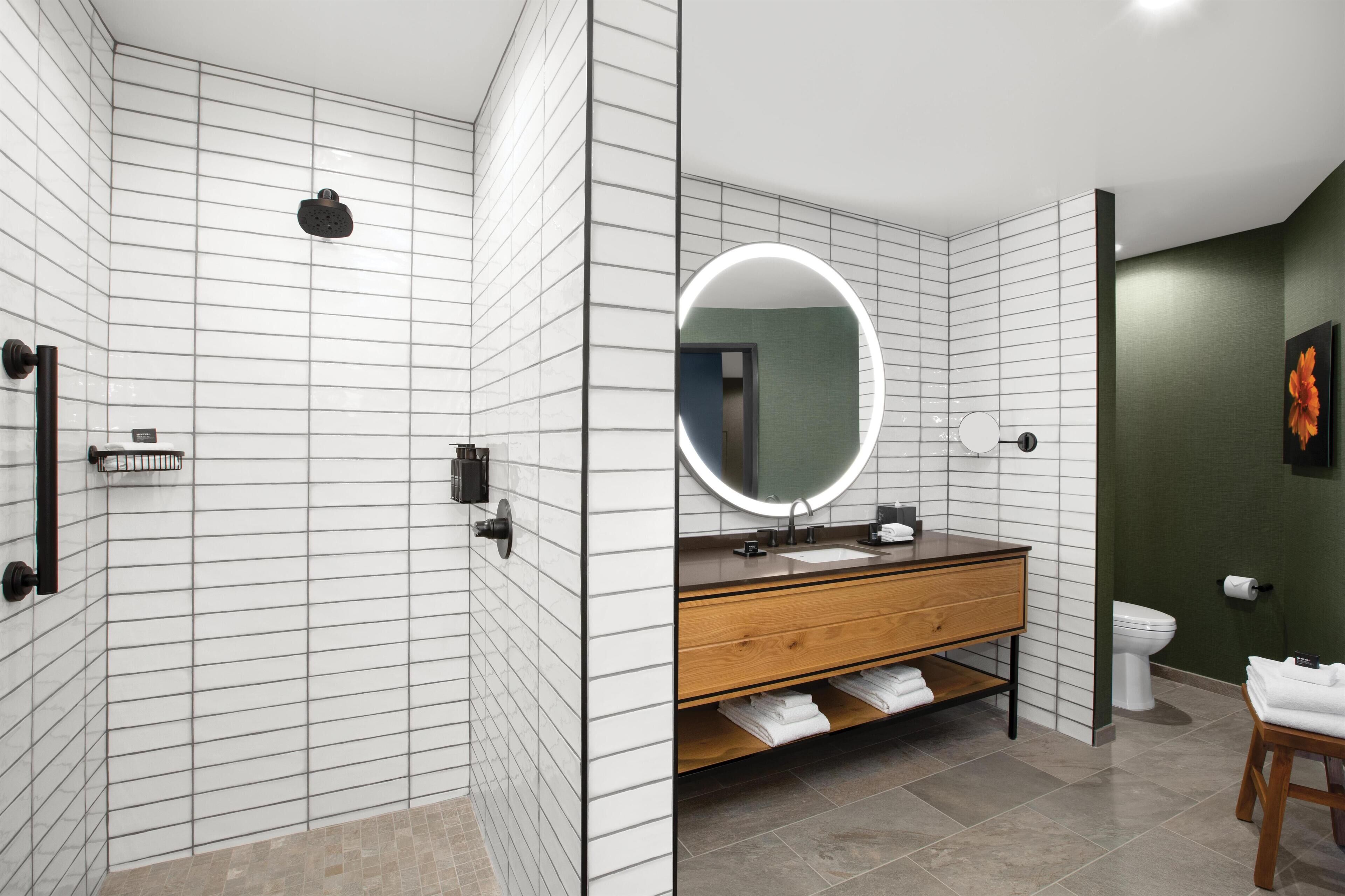 A modern bathroom with a shower, toilet, and vanity.
