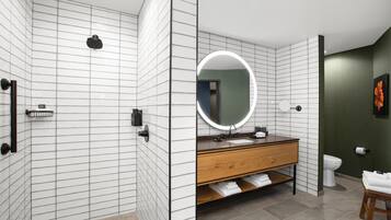 A modern bathroom with a shower, toilet, and vanity.
