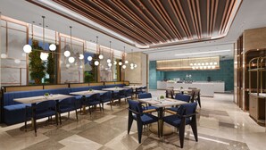 Un restaurant modern amb seients blaus, una illa central i un sostre decoratiu.