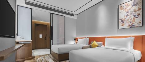 A modern hotel room with two beds, a desk, and a large abstract painting on the wall.