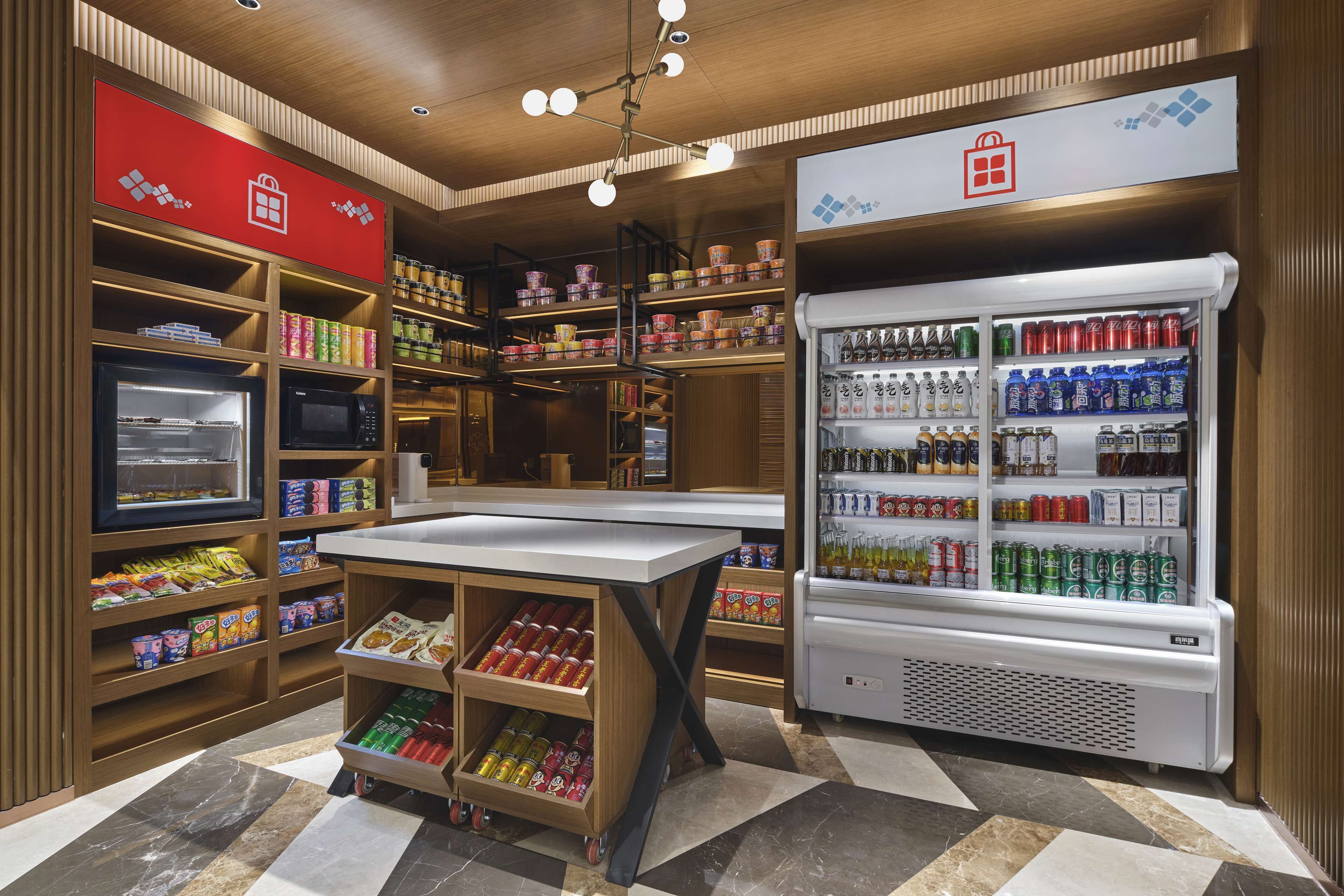 A well-organized convenience store with shelves stocked with snacks, beverages, and refrigerated items.