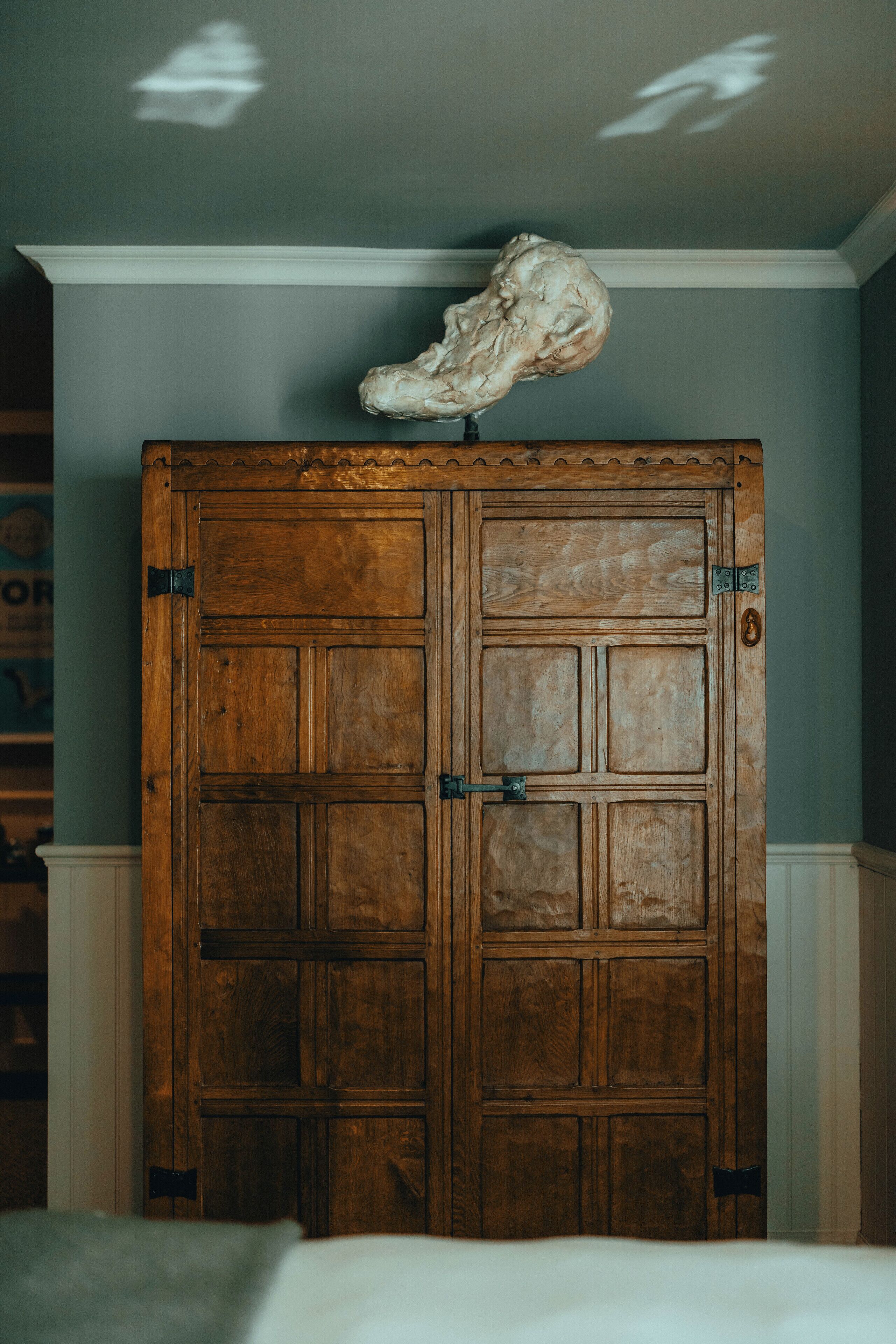 Una porta doppia in legno con una grande scultura bianca e astratta sopra.
