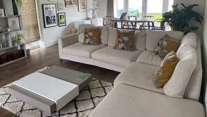 Ett vardagsrum med en soffa, ett soffbord och en matplats med ett bord och stolar.