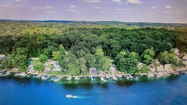 An aerial view of a coastal area with dense greenery, a marina with boats, and a small settlement with buildings. - NEW Beautiful, Spacious Lake House  (Angola)