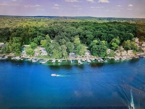 An aerial view of a coastal area with dense greenery, a marina with boats, and a small settlement with buildings. - NEW Beautiful, Spacious Lake House (Angola)