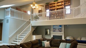 A multi-level living room with a staircase, a fireplace, and a bookshelf. - NEW Beautiful, Spacious Lake House  (Angola)