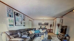 A living room with a sectional sofa, a coffee table, and a fireplace. - NEW Beautiful, Spacious Lake House  (Angola)
