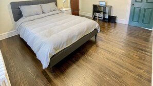 A bedroom with a bed, a nightstand, a desk, and a door. - Entire 3 Bedroom Cozy Unit (Waukegan)