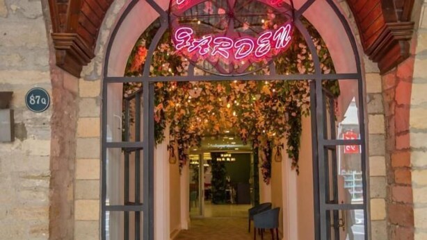 A storefront with a neon sign reading "GARDEN" and a brick facade.