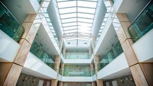 A modern atrium with a glass ceiling and wooden accents.