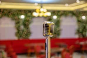 A microphone in a room with red seating and a chandelier. - Grand Midway Hotel (Baku)