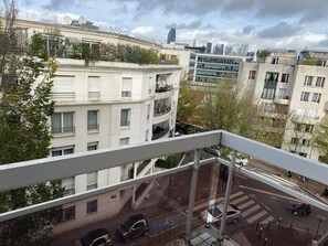 A high-rise building with multiple balconies, a pedestrian crossing, and a clear view of the cityscape in the background. - Studio Avec Balcon, Centre-ville, Proche des Transports Bus, Tram, Train (SURESNES)